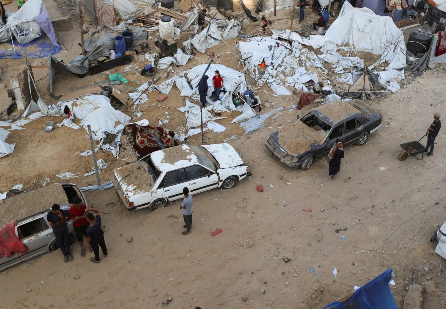 فلسطينيون يتجمعون في موقع غارة إسرائيلية على مدينة غزة (رويترز)