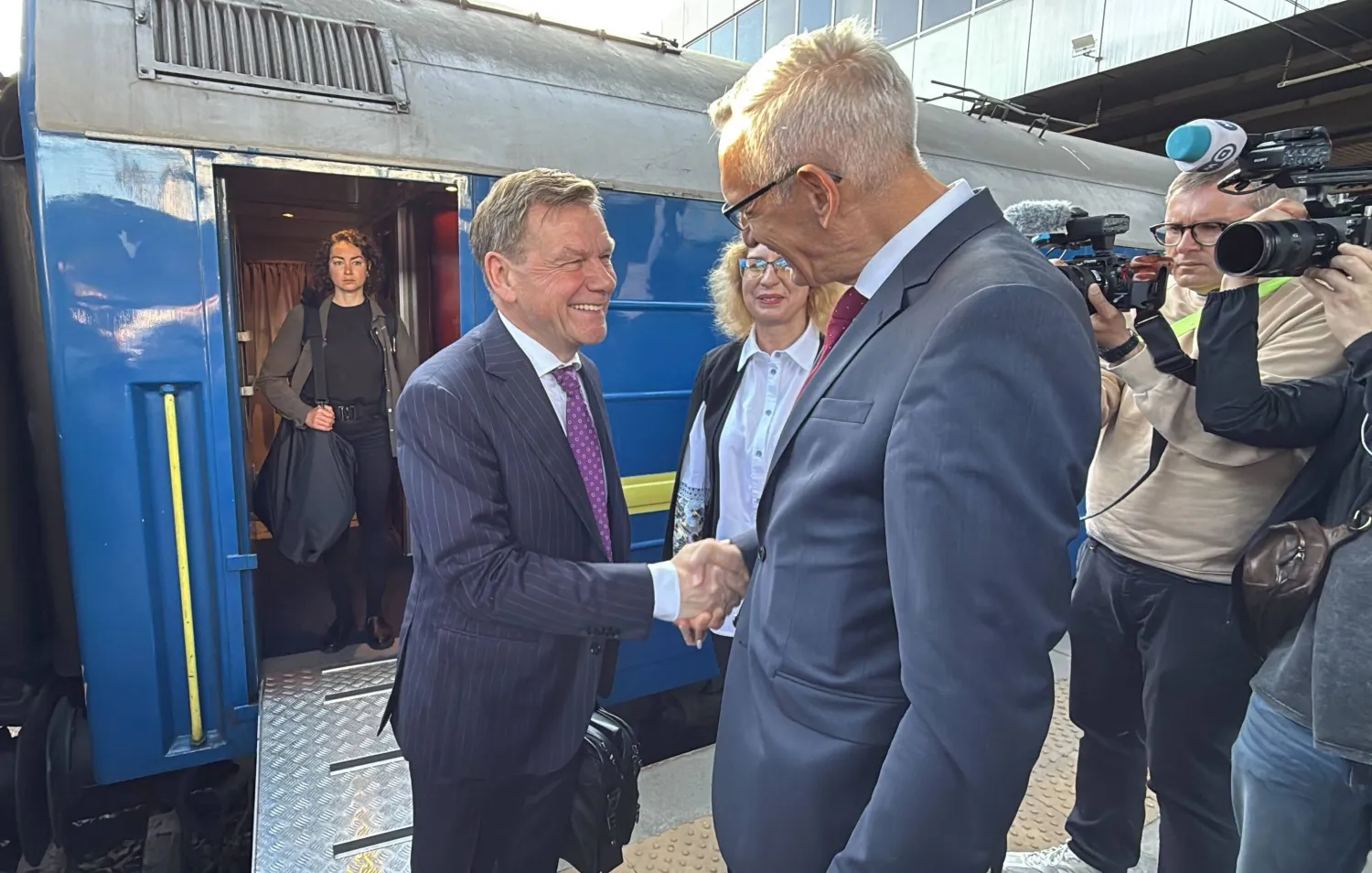 السفير الألماني مارتن ياغر (يمين) يحيي وزير الخارجية الألماني يوهان فاديفول (يسار) لدى وصوله إلى محطة القطار في كييف (د.ب.أ)