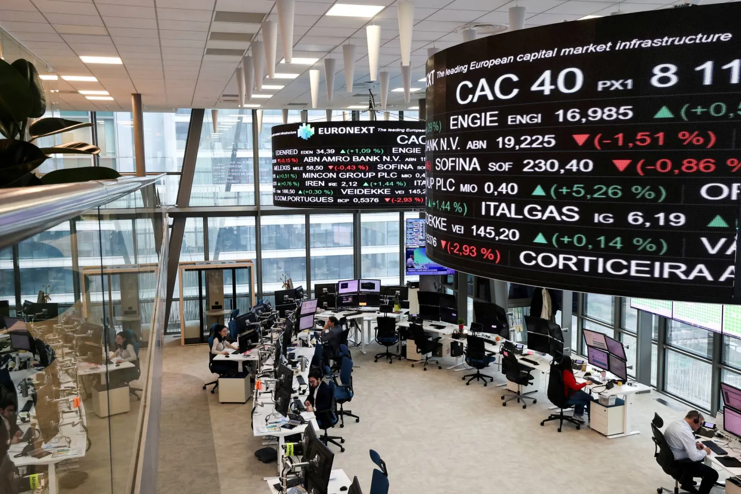 أشخاص يعملون بقاعة التداول في بورصة يورونيكست بباريس (رويترز)