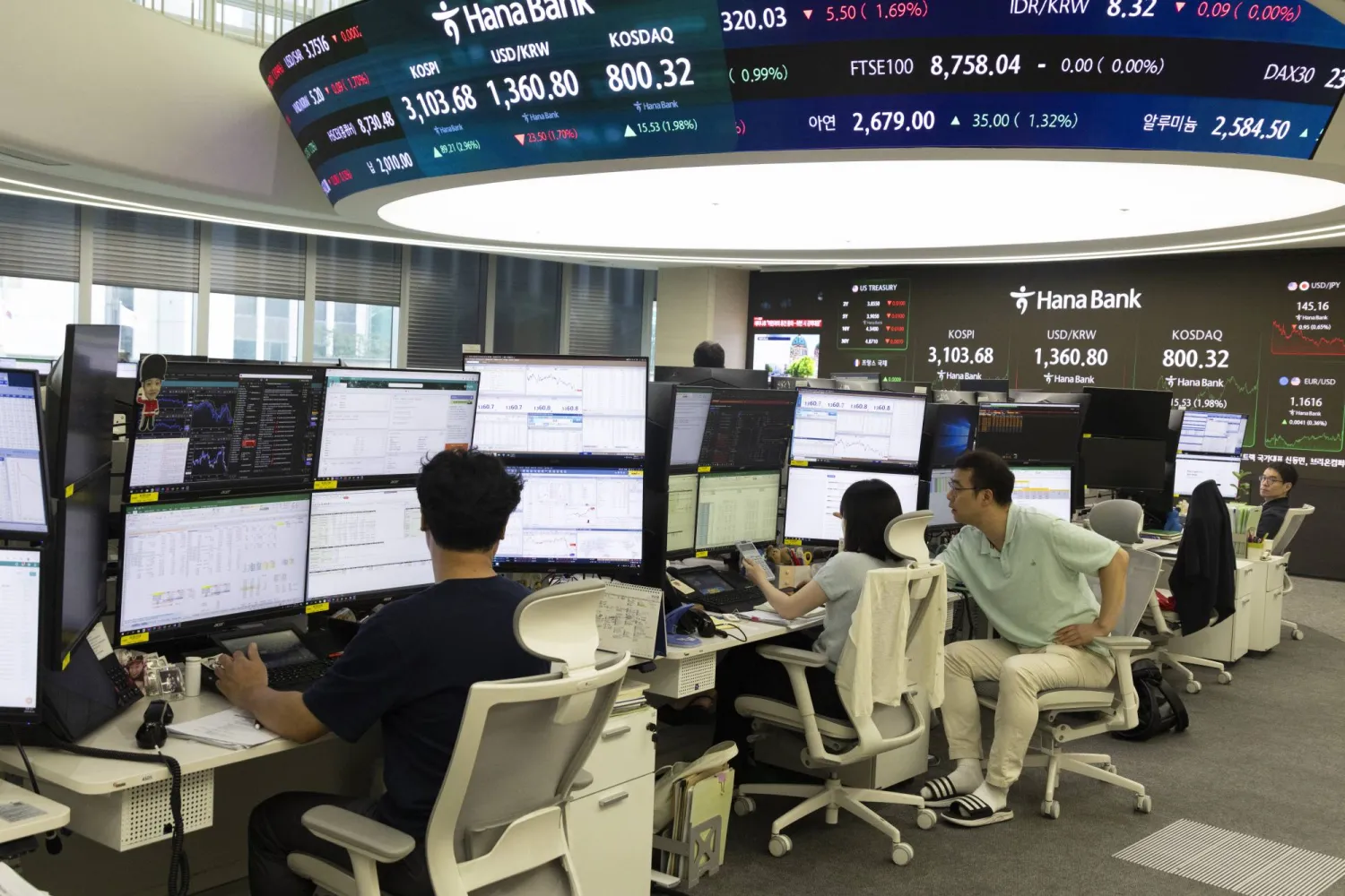 متداولون كوريون يتابعون مؤشر «كوسبي» في بنك «هانا» بسيول (إ.ب.أ)