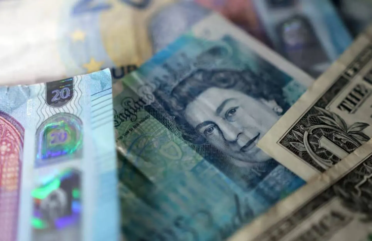 صورة توضيحية لأوراق نقدية من الجنيه الإسترليني والدولار الأميركي (رويترز)