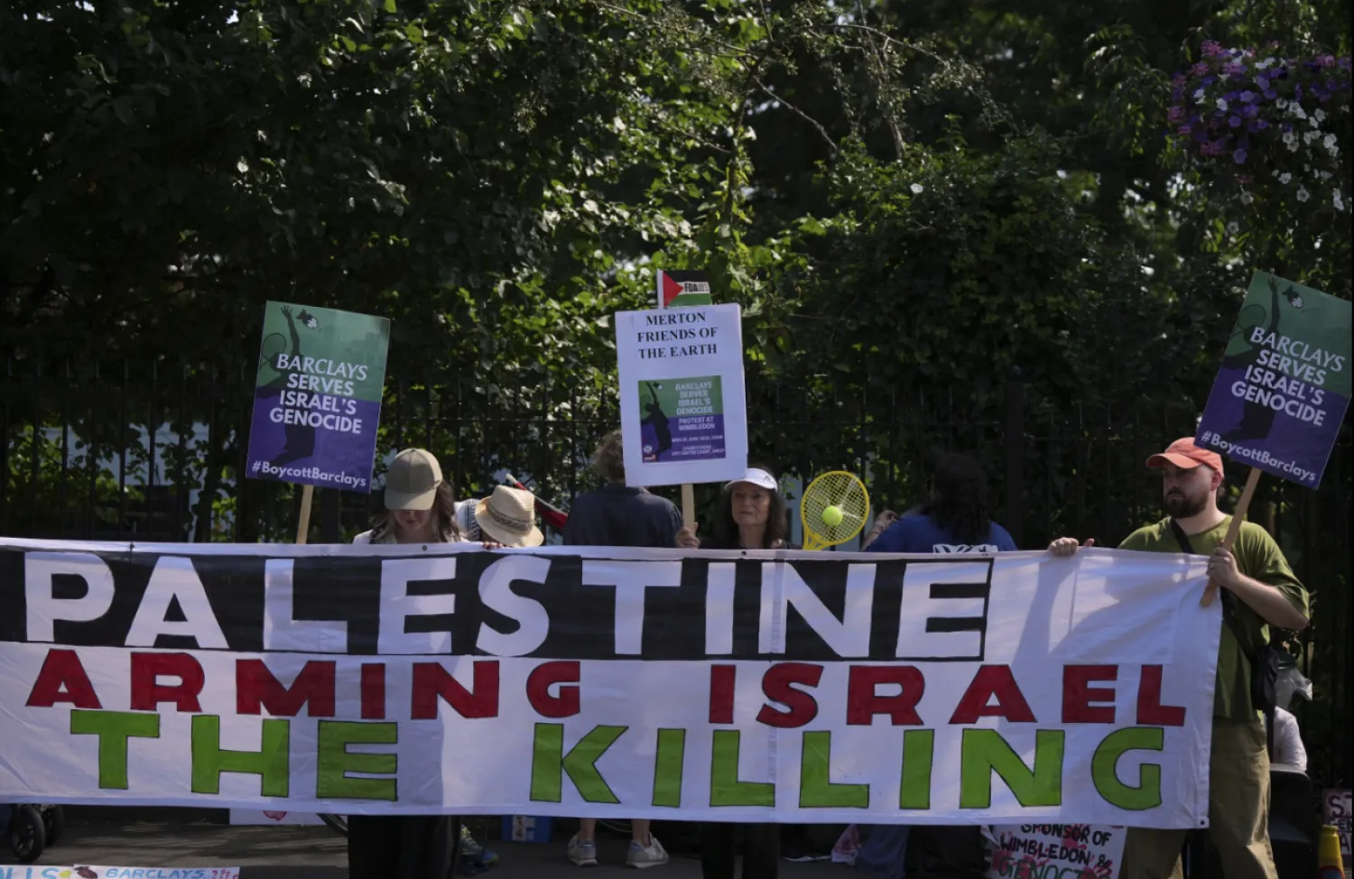 Protesters of the Palestine Solidarity Campaign against the tournament's sponsor Barclays gather outside the Wimbledon Tennis Championships in London, Monday, June 30, 2025. (AP Photo/Alastair Grant)