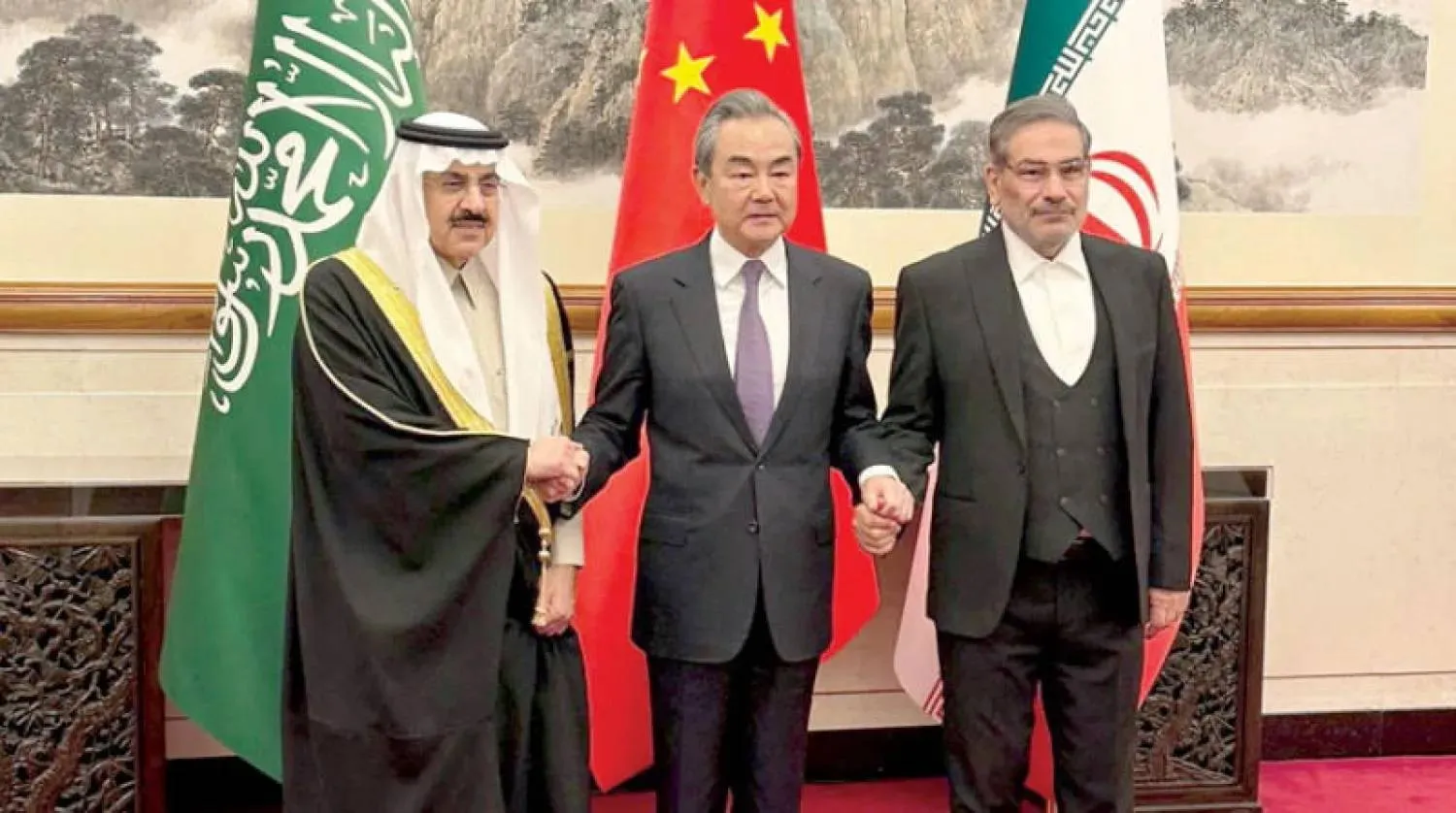 وانغ يي يتوسط رئيسي الوفدين السعودي الدكتور مساعد العيبان والإيراني الأدميرال علي شمخاني في بكين مارس 2023 (واس)