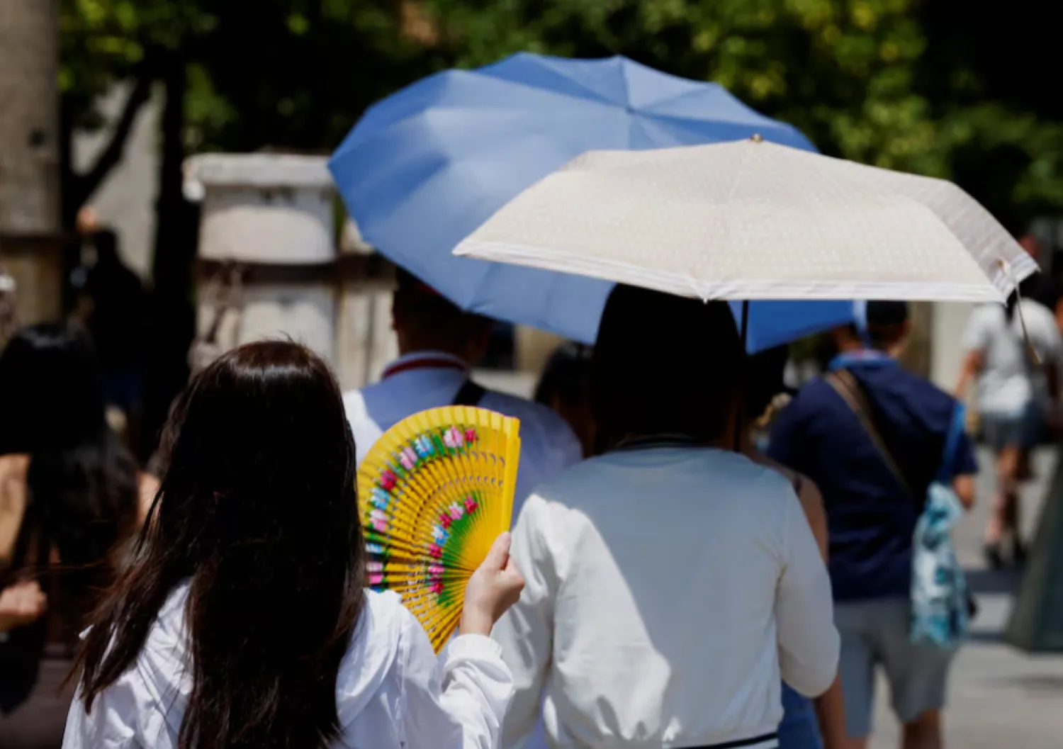 A woman uses a hand fan to cool off during the first summer heatwave in Seville, southern Spain June 29, 2025. REUTERS/Marcelo del Pozo 