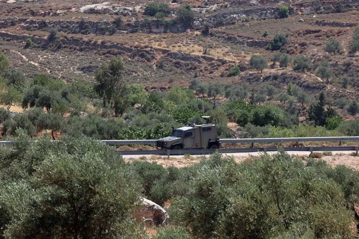 An Israeli military vehicle patrols nearby as a diplomatic delegation from the European Union (not pictured) inspects the damage at Kafr Malik village in the occupied West Bank on June 30, 2025, following an attack by Israeli settlers on June 25 that killed at least three Palestinians. (AFP)