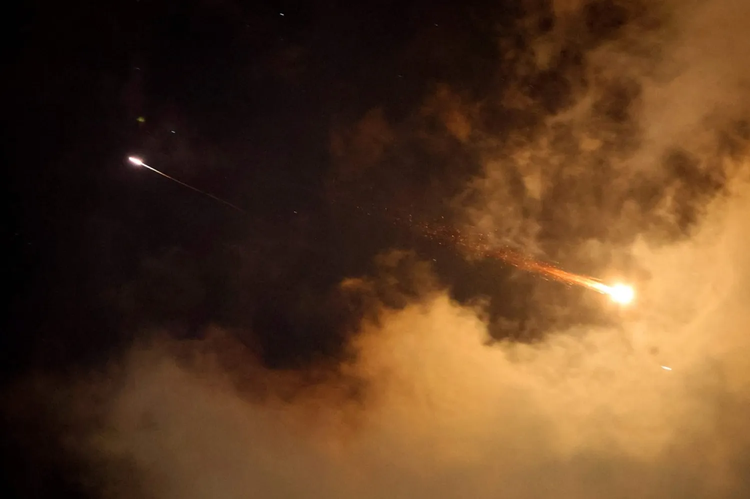 Rocket trails are seen in the sky above the Israeli coastal city of Netanya amid a fresh barrage of Iranian missile attacks on June 21, 2025. (AFP) 