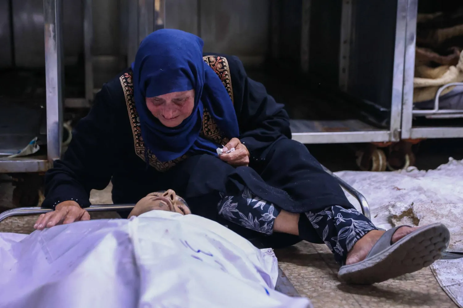 امرأة فلسطينية تنعى جثمان قريب لها قُتل في غارة إسرائيلية على كافتيريا الباقة على شاطئ مدينة غزة بمستشفى الشفاء (أ.ف.ب)