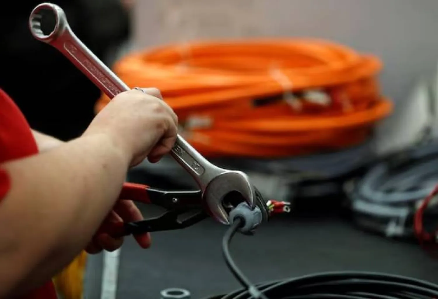 عامل يركب موصلاً على سلك كهربائي في مصنع بالقرب من كانوك (رويترز)