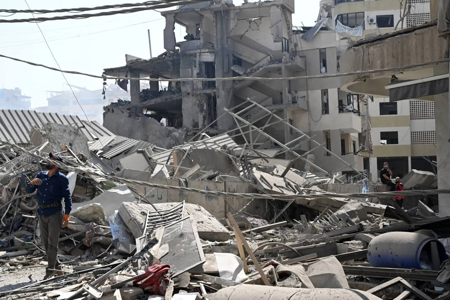 رجل يعاين الدمار الذي أحدثته الغارات الإسرائيلية على الضاحية الأسبوع الماضي (إ.ب.أ)