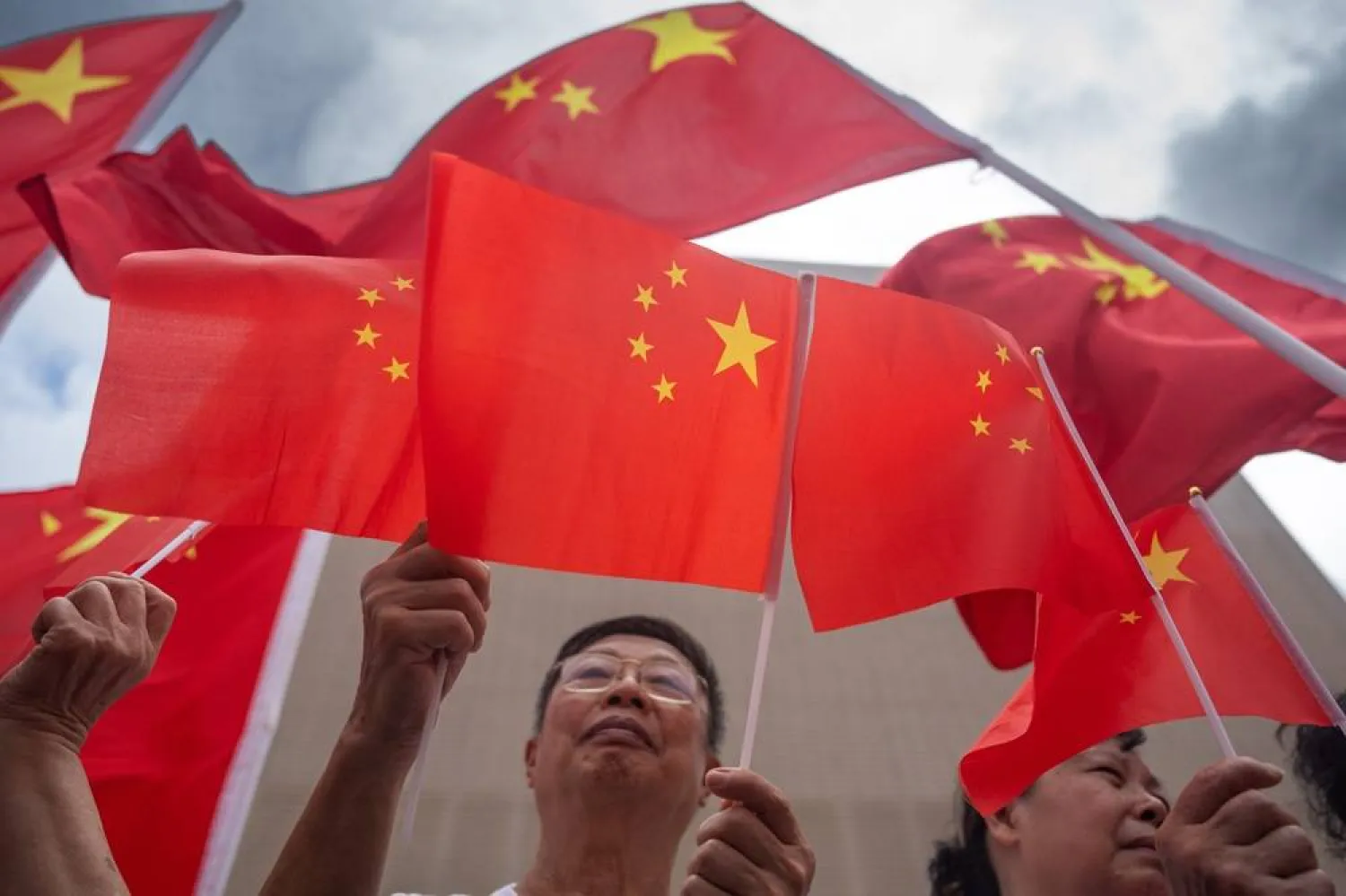 Attendees wave People's Republic of China flags during celebrations of the handover of Hong Kong, in Hong Kong, China, 01 July 2025. July 01, 2025 marks the 28th anniversary of the handover of Hong Kong to China as a Special Administrative Region, after more than 150 years as a British colony. (EPA)