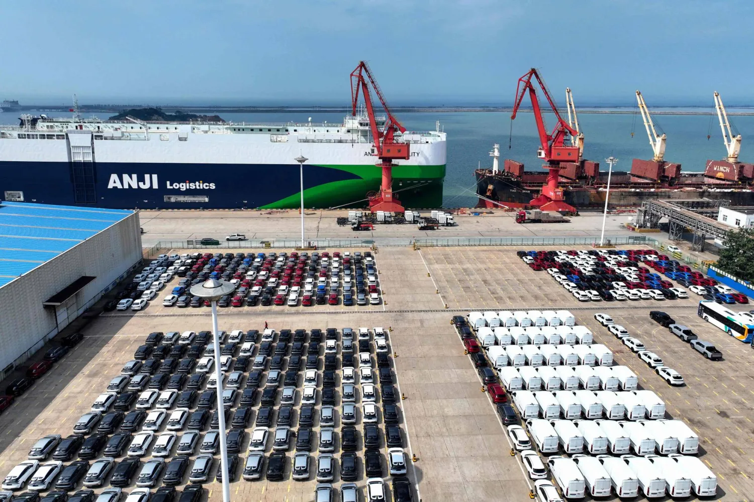 آلاف السيارات في طريقها إلى الشحن بميناء ليانينغانغ شرق الصين (أ.ف.ب)