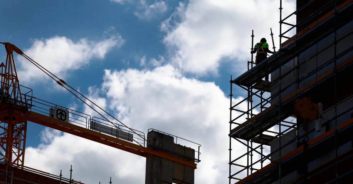 عامل يزيل السقالات في موقع بناء بجزيرة زوروتساورّي في بلباو بإسبانيا (رويترز)