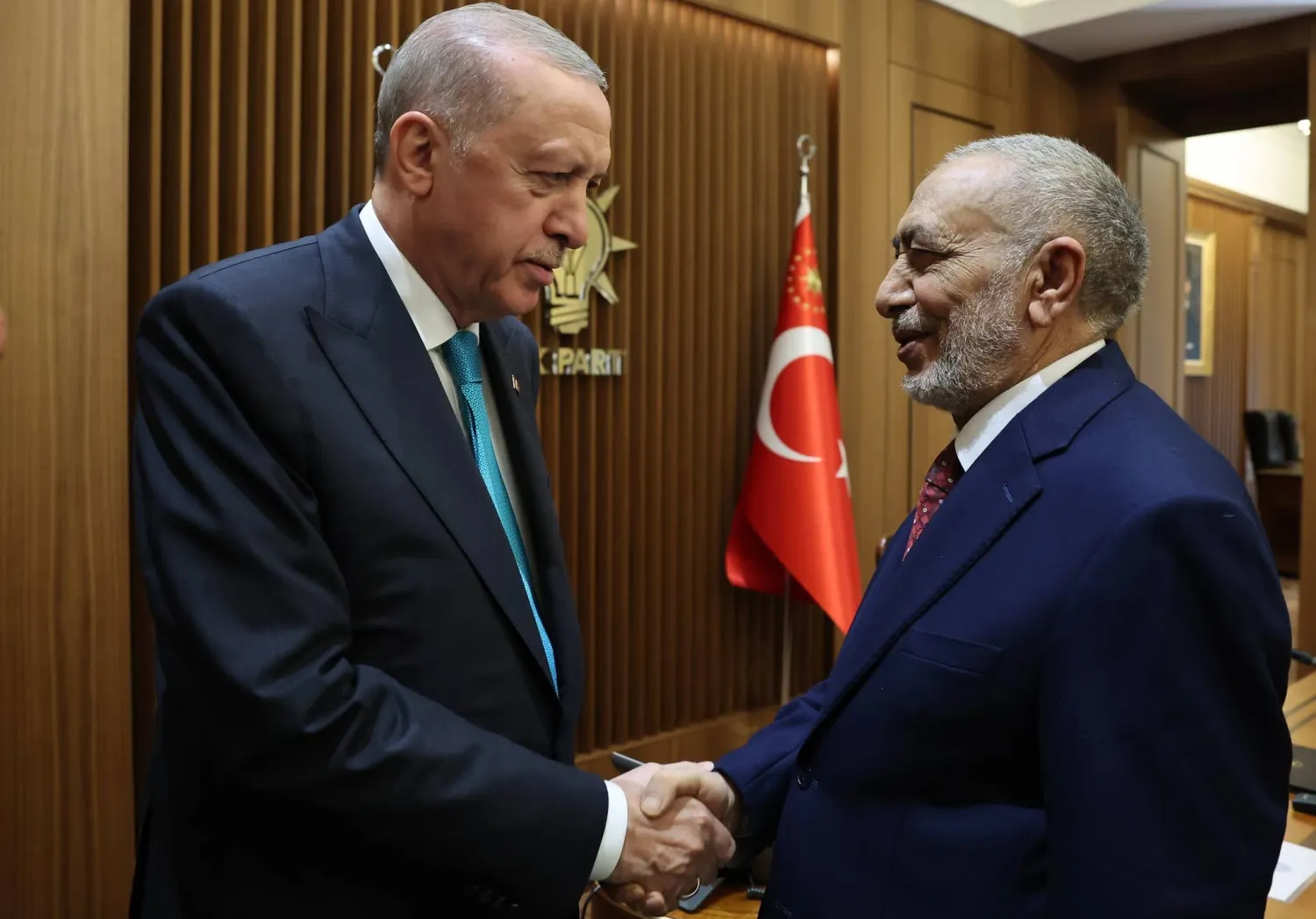 الرئيس التركي رجب طيب إردوغان مصافحاً رئيس البرلمان العراقي محمود المشهداني في أنقرة (إعلام البرلمان)