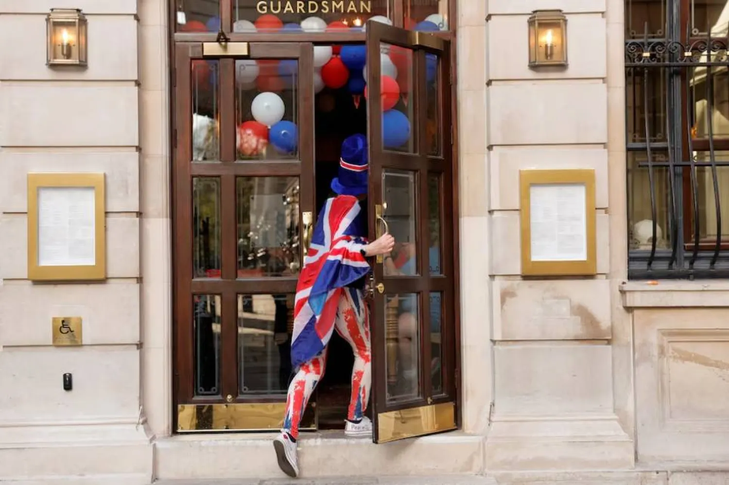 امرأة تكتسي بعلم بريطانيا تدخل مطعماً في لندن (رويترز)