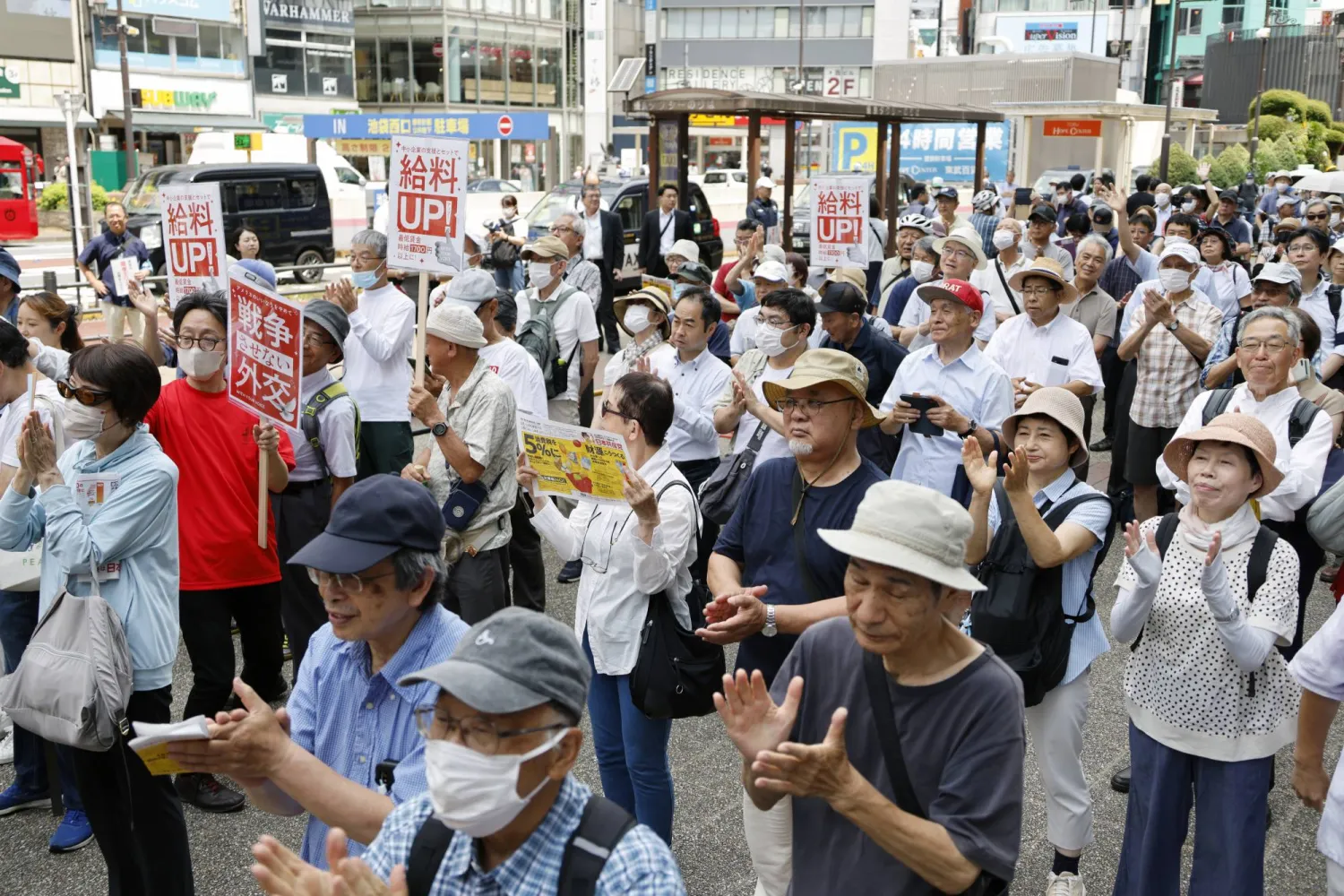 يابانيون في أحد شوارع العاصمة طوكيو خلال حملة تسبق انتخابات مجلس الشيوخ الوشيكة (إ.ب.أ)