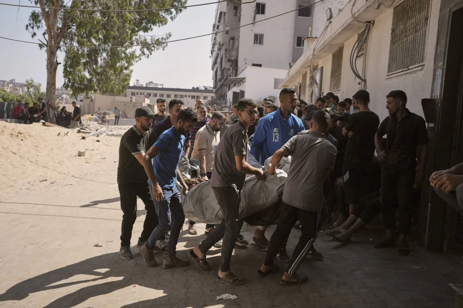 فلسطينيون يحملون جثامين أم وأطفالها إلى مستشفى الشفاء في مدينة غزة بعد أن قُتلوا اليوم (أ.ب)