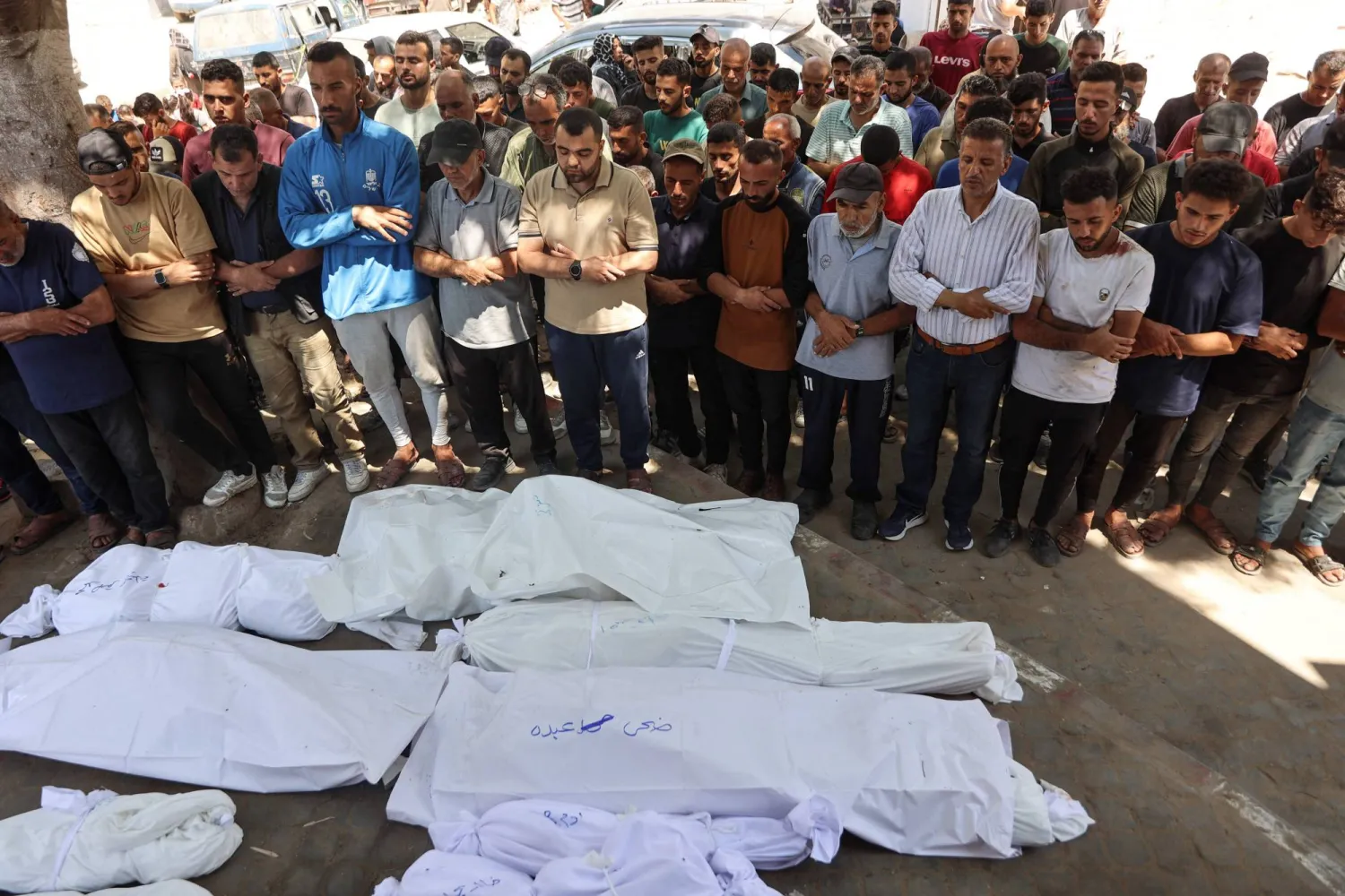 فلسطينيون يصلون على جثامين ضحايا غارة إسرائيلية استهدفت مدرسة في غزة يوم الخميس (أ.ف.ب)