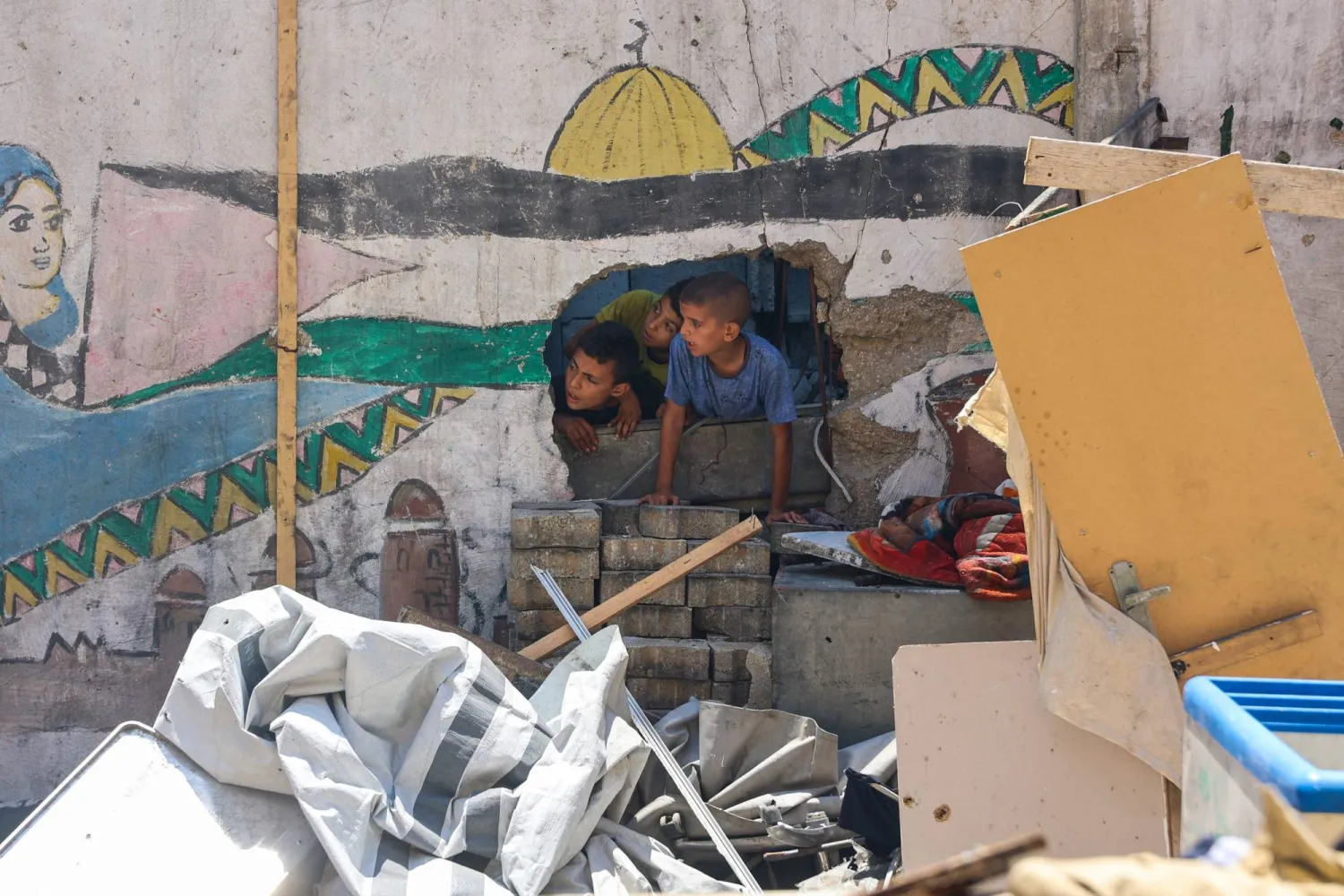 Children check the destruction at Mustafa Hafez school, sheltering Palestinians displaced by the war, after the school was hit during an overnight Israeli strike in Gaza City, on July 3, 2025, amid the ongoing conflict between Israel and the Palestinian Hamas group. (Photo by Omar AL-QATTAA / AFP)