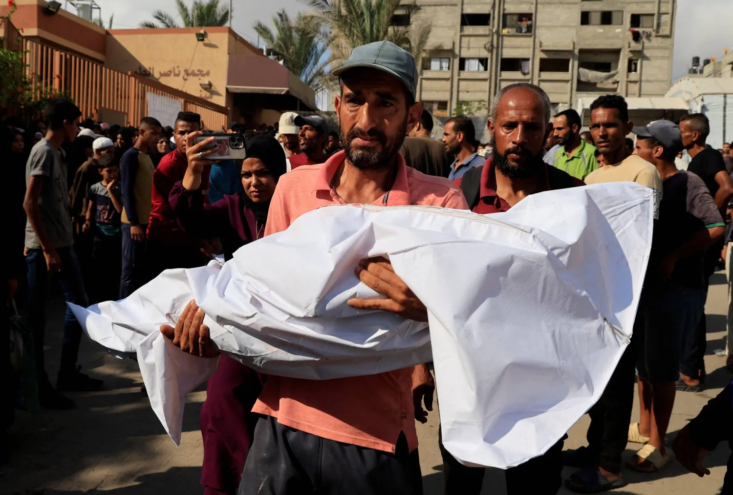 A man carries the body of a child during the funeral of Palestinians killed overnight in Israeli attacks on a tent and on people seeking aid, according to Gaza's health ministry, at Nasser Hospital in Khan Younis, southern Gaza Strip, July 4, 2025. REUTERS/Hatem Khaled