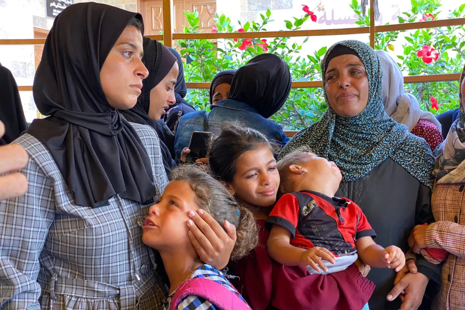نساء وأطفال يبكون خلال جنازة فلسطينيين قُتلوا في غارات إسرائيلية على جنوب قطاع غزة (أ.ف.ب)
