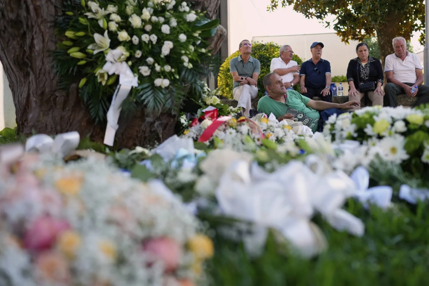 People wait next to flowers to enter at a church where the bodies of Liverpool forward Diogo Jota and André Silva have been brought for a wake and funeral in Gondomar, near Porto, Portugal, on Friday, July 4, 2025. (AP Photo/Manu Fernandez)