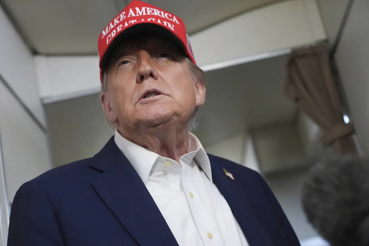 President Donald Trump speaks to reporters on board Air Force One, en route from Joint Base Andrews, Md., to Morristown Municipal Airport in Morristown, N.J., Friday, July 4, 2025. (AP Photo/Jacquelyn Martin)
