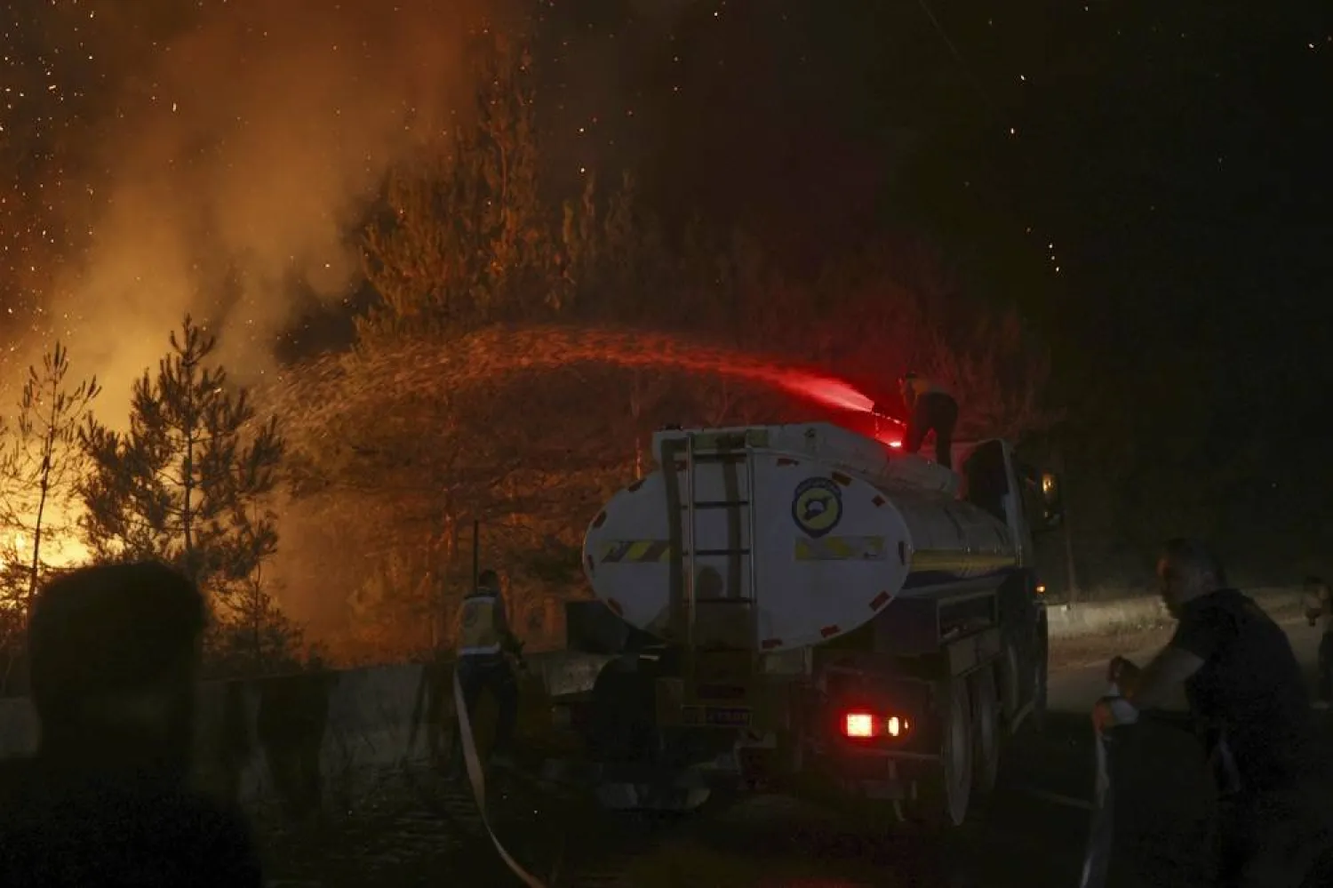 An emergency responder with the Syrian Civil Defense, known as the White Helmets, works to extinguish a wildfire in the town of Rabia, in Latakia province, Syria, Saturday, July 5, 2025. (AP) 