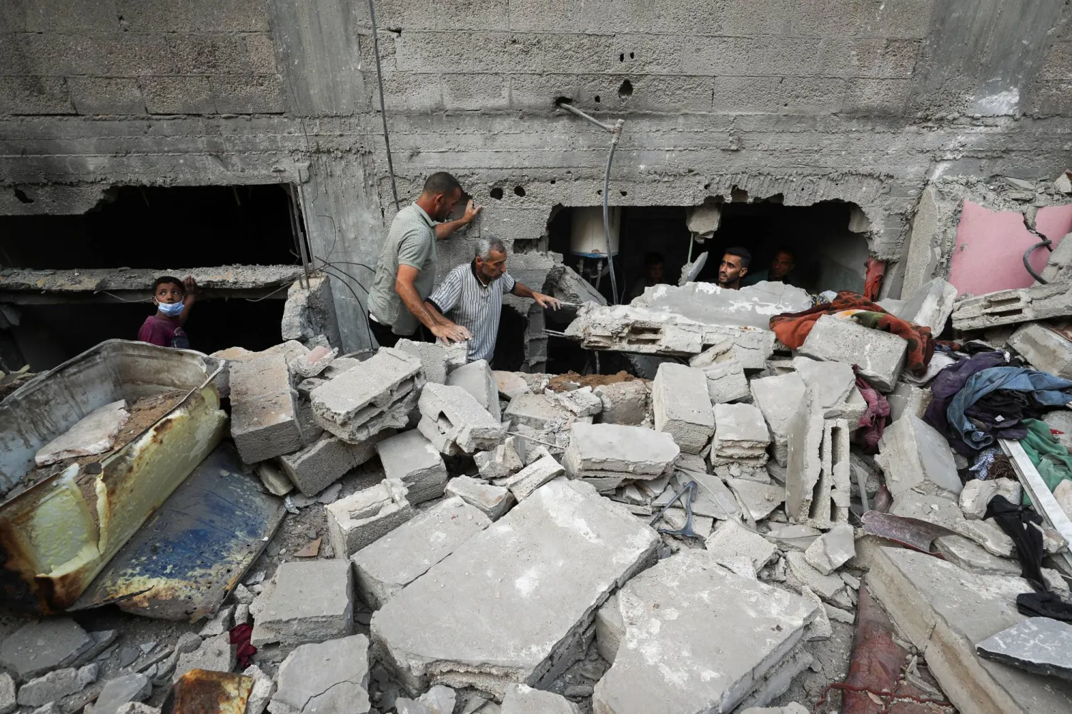 فلسطينيون يبحثون عن ضحايا في موقع غارة إسرائيلية ليلية على مدينة غزة (رويترز)