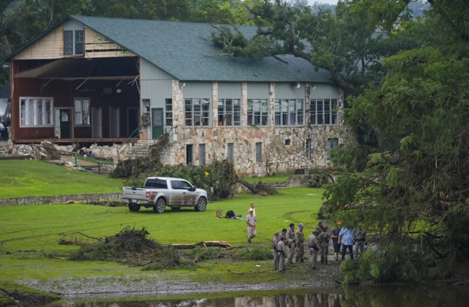 Officials search on the grounds of Camp Mystic along the banks of the Guadalupe River after a flash flood swept through the area Sunday, July 6, 2025, in Hunt, Texas. (AP Photo/Julio Cortez)