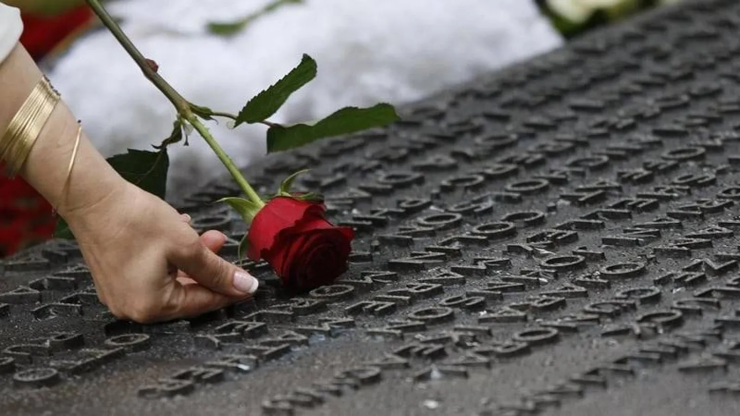 امرأة تلمس اسم أحد ضحايا تفجيرات لندن في 7 يوليو 2005 المنقوش على لوحة بالنصب التذكاري (متداولة)