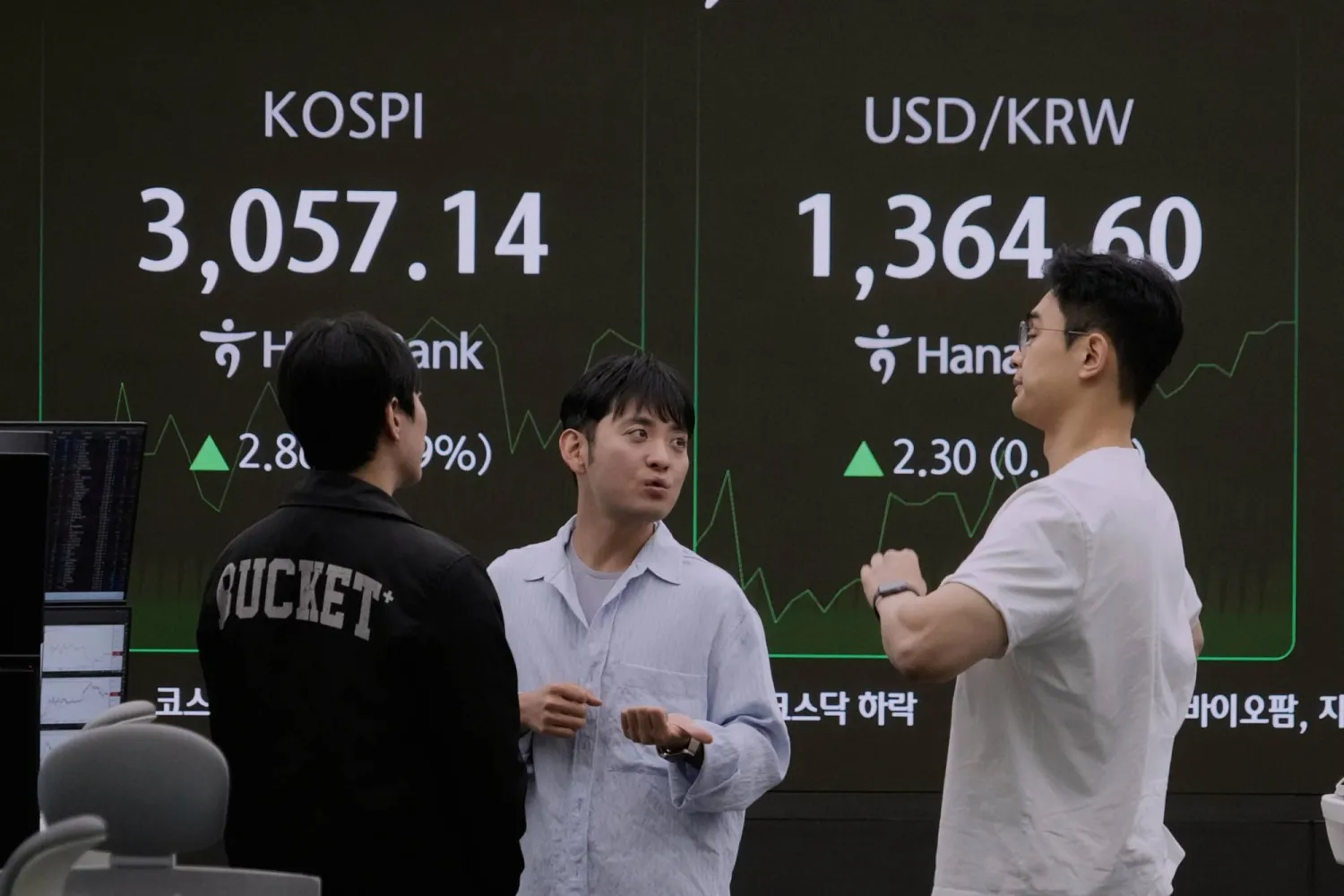 متداولو عملات أمام شاشة مؤشر «كوسبي» وسعر صرف الدولار مقابل الوون في بنك هانا بسيول (أ.ب)