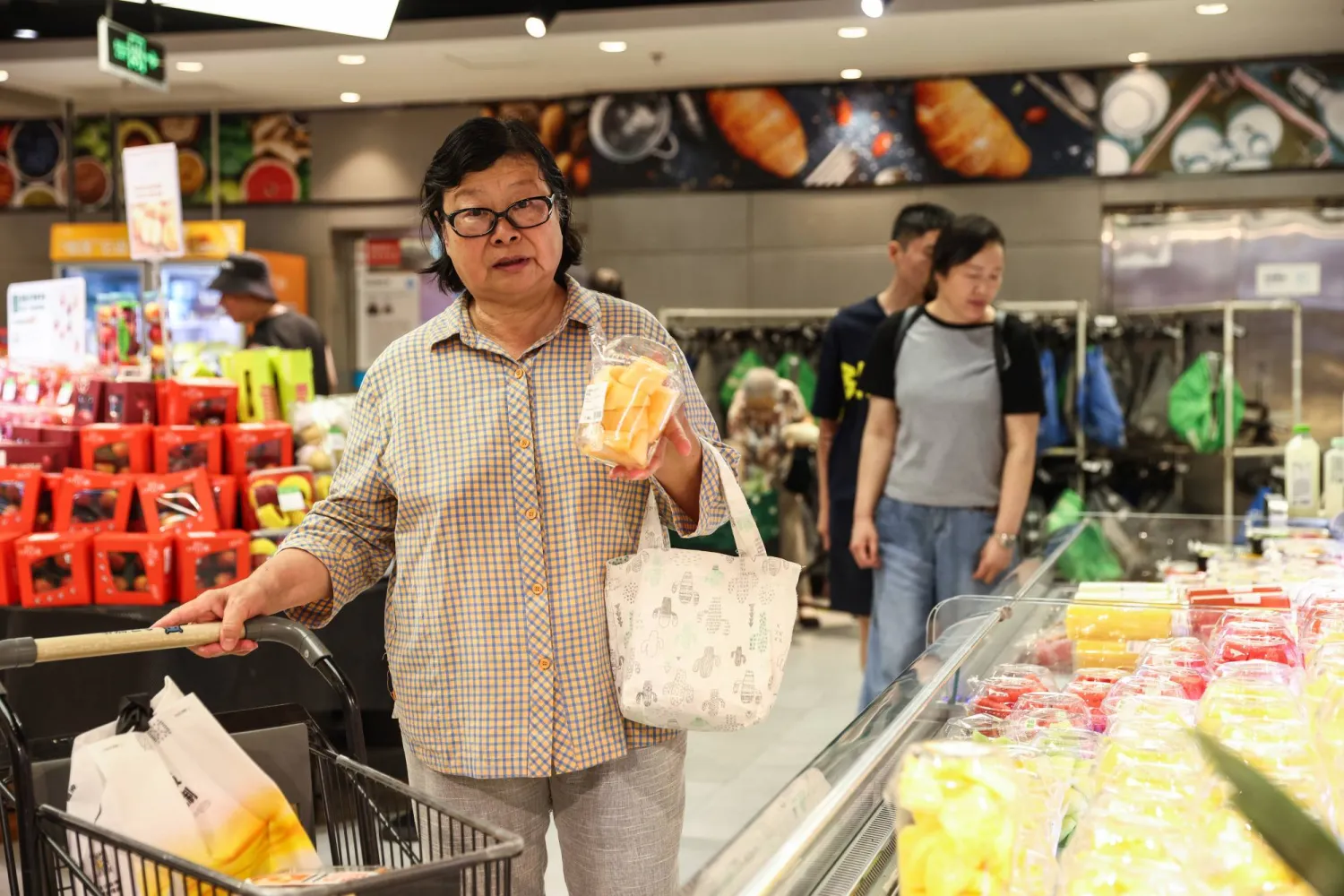 متسوقون في أحد المراكز التجارية بالعاصمة الصينية بكين (إ.ب.أ)