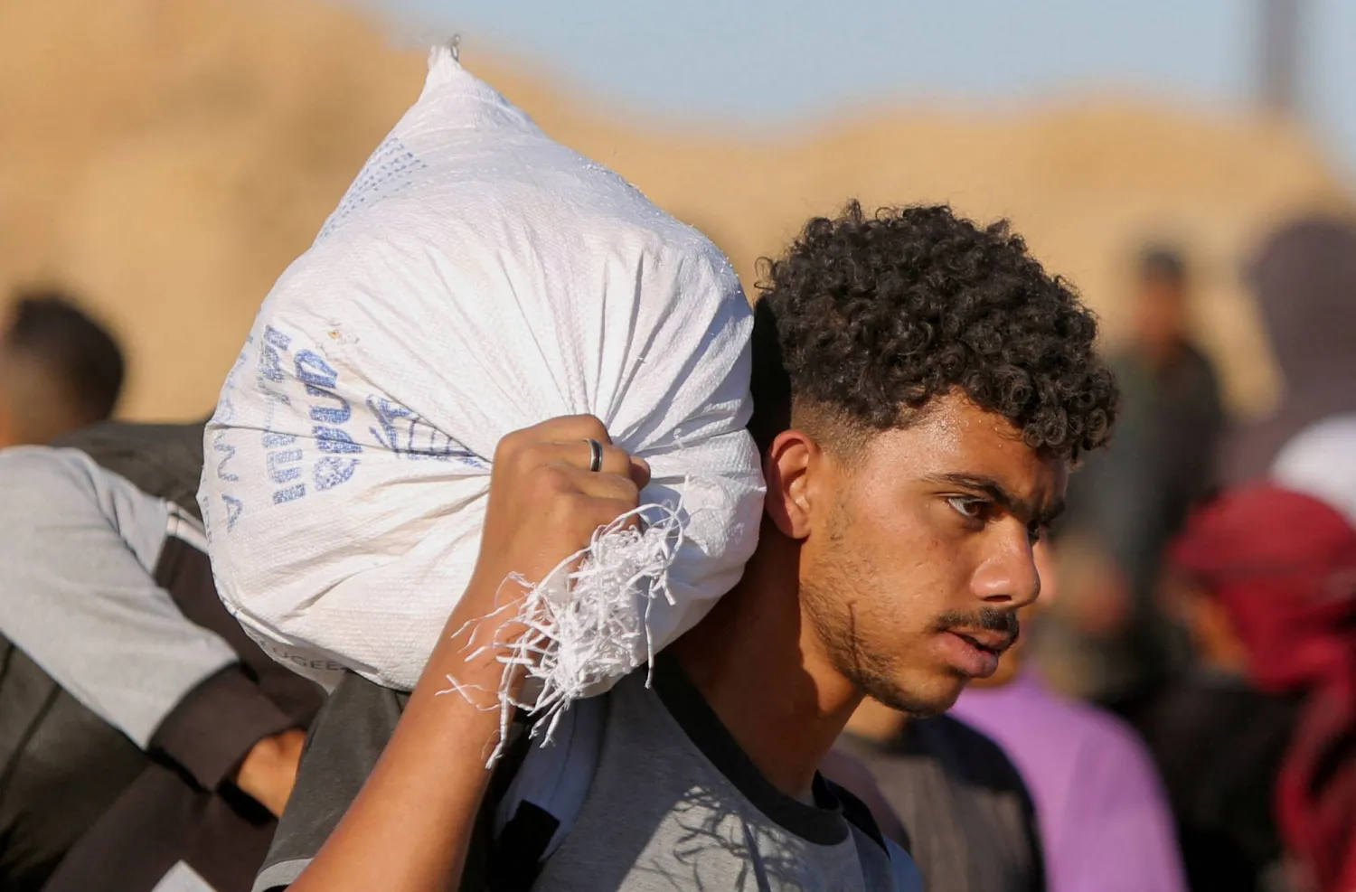 فلسطيني يحمل مساعدات من مؤسسة غزة الإنسانية التي تدعمها الولايات المتحدة (رويترز)