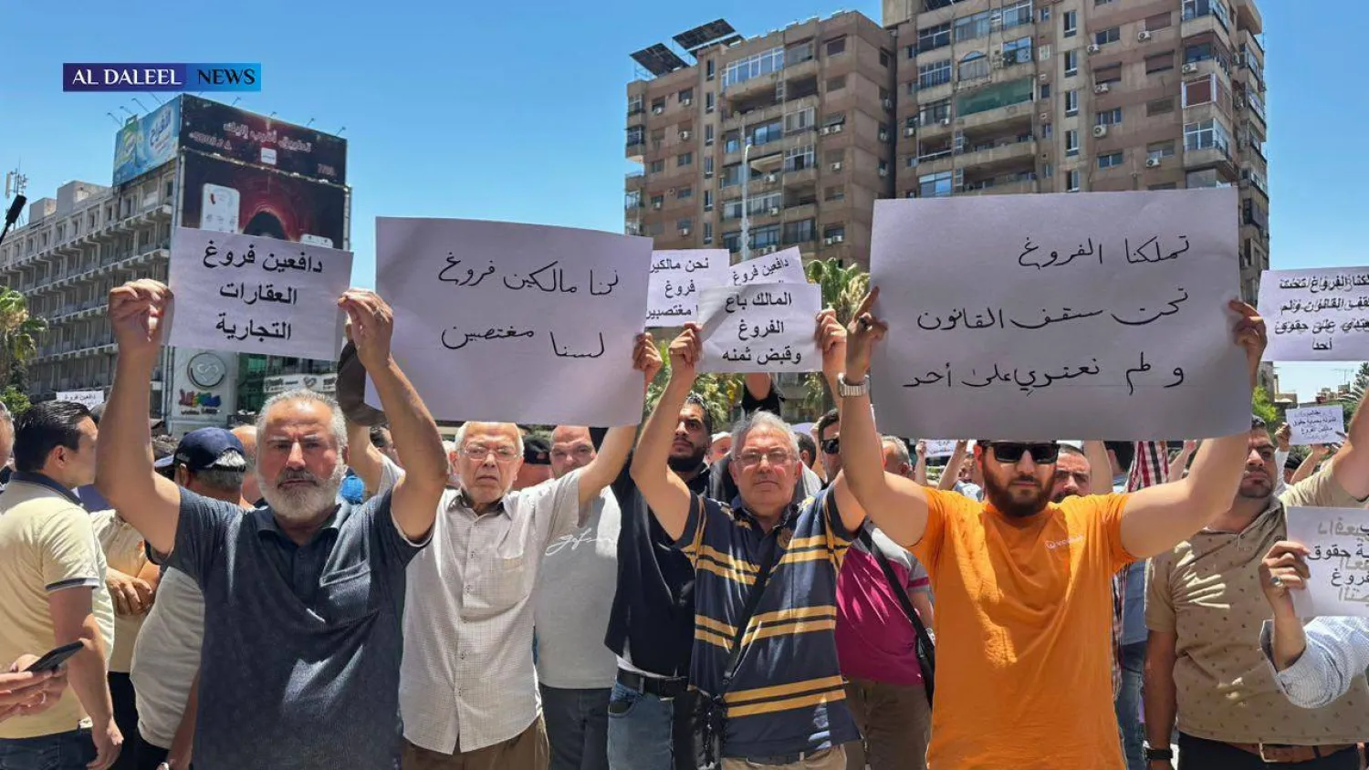 لافتات رفعها تجار دمشق أمام القصر العدلي (سانا)