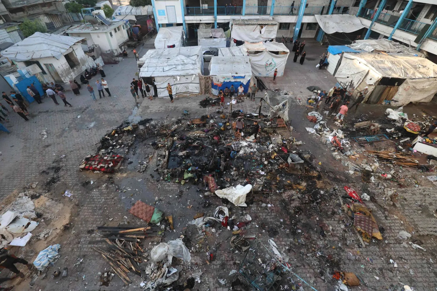 فلسطينيون يتفقدون الدمار الذي خلفته غارة إسرائيلية استهدفت مدرسةً تؤوي نازحين فلسطينيين في مخيم البريج وسط قطاع غزة (أ.ف.ب)