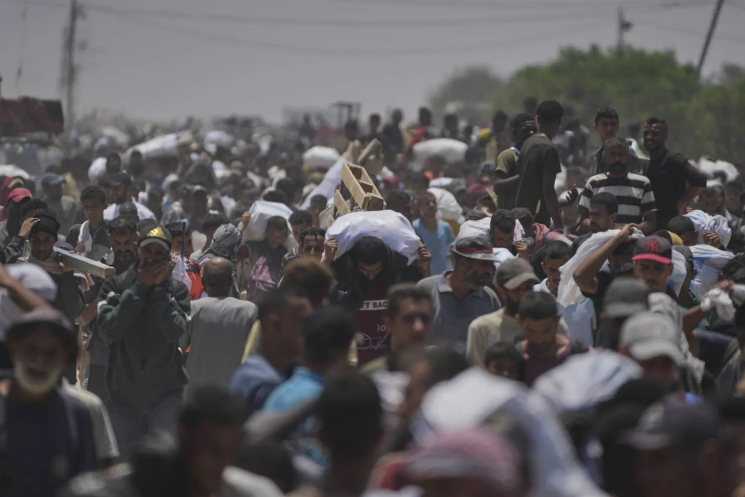 فلسطينيون يحملون أكياساً تحوي مساعدات غذائية وزعتها «مؤسسة غزة الإنسانية» في رفح (أ.ب)