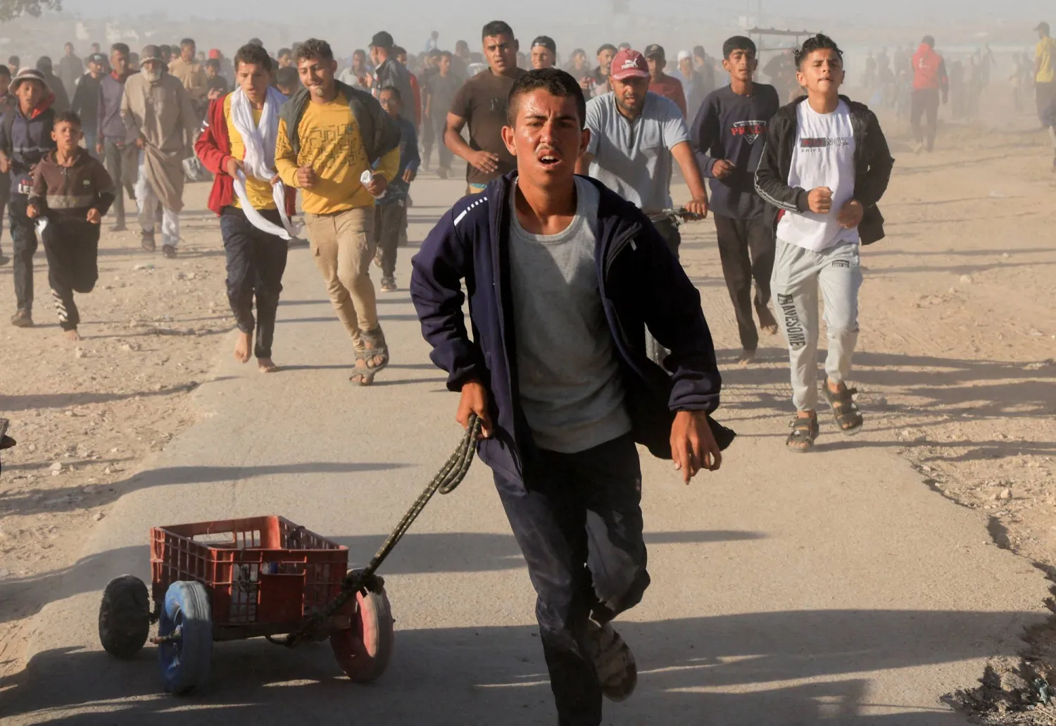 فلسطينيون يسيرون للحصول على إمدادات المساعدات من «مؤسسة غزة الإنسانية» المدعومة من الولايات المتحدة في خان يونس (رويترز)