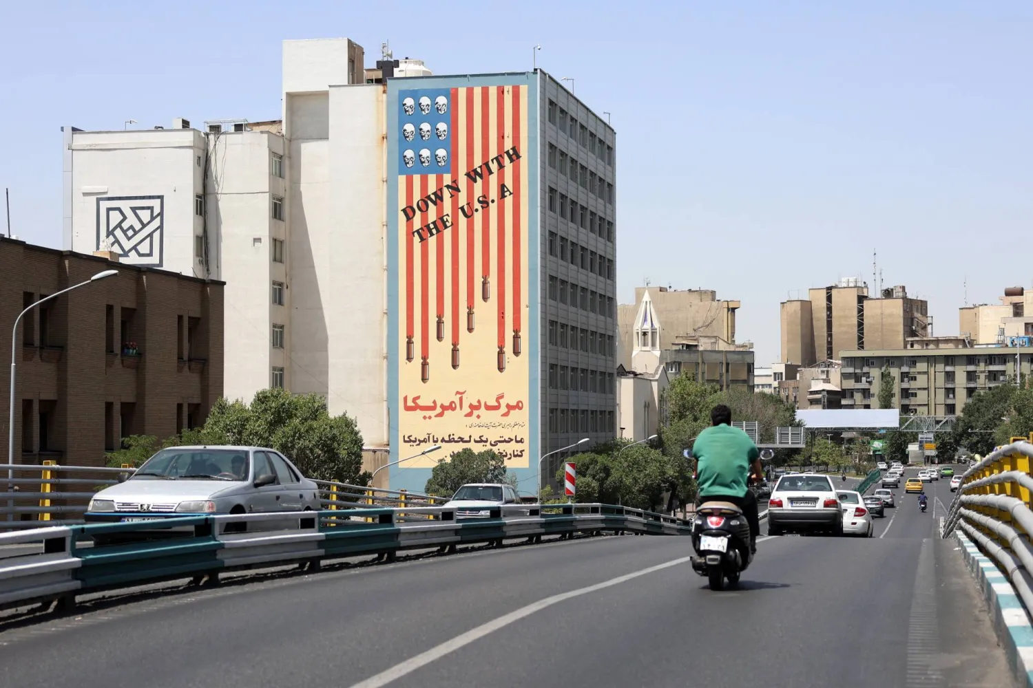 سيارات تمر أمام مبنى يحمل لوحة جدارية مناهضة للولايات المتحدة في طهران 22 يونيو 2025 (إ.ب.أ)