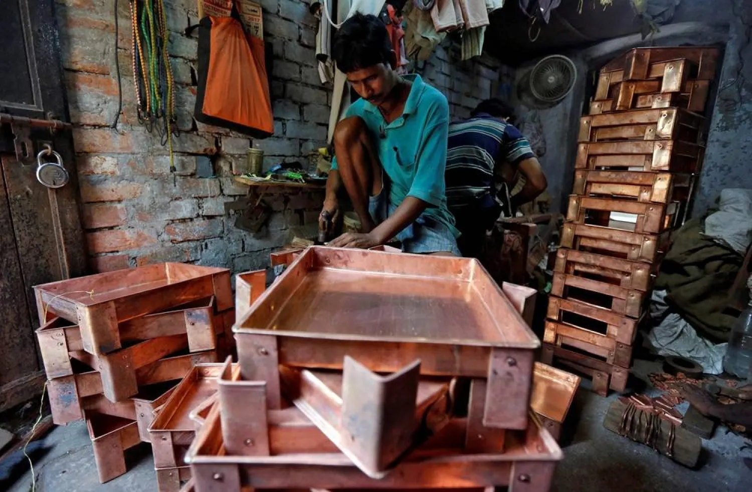 A worker makes copper trays inside a workshop in Kolkata, India, October 26, 2017. Picture taken October 26, 2017. (Reuters)