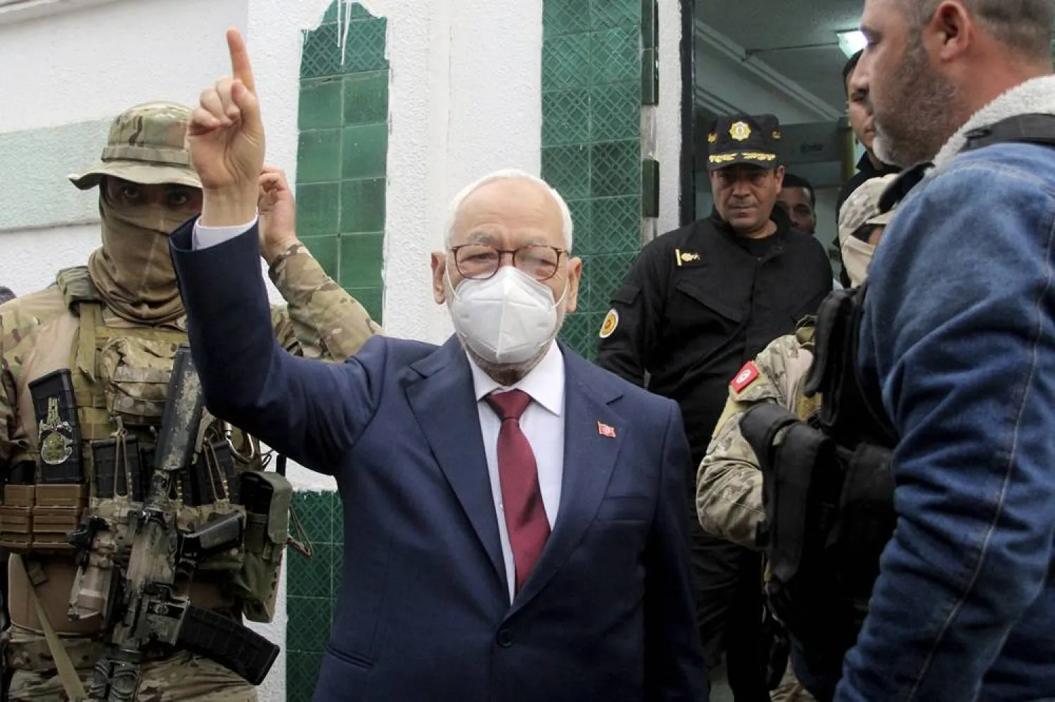 Leader of Tunisia's Ennahda party House Speaker Rached Ghannouchi, center, flashes a victory sign as he arrives for questioning at the judicial police headquarters in Tunis, Tunisia, April 1, 2022. (AP)