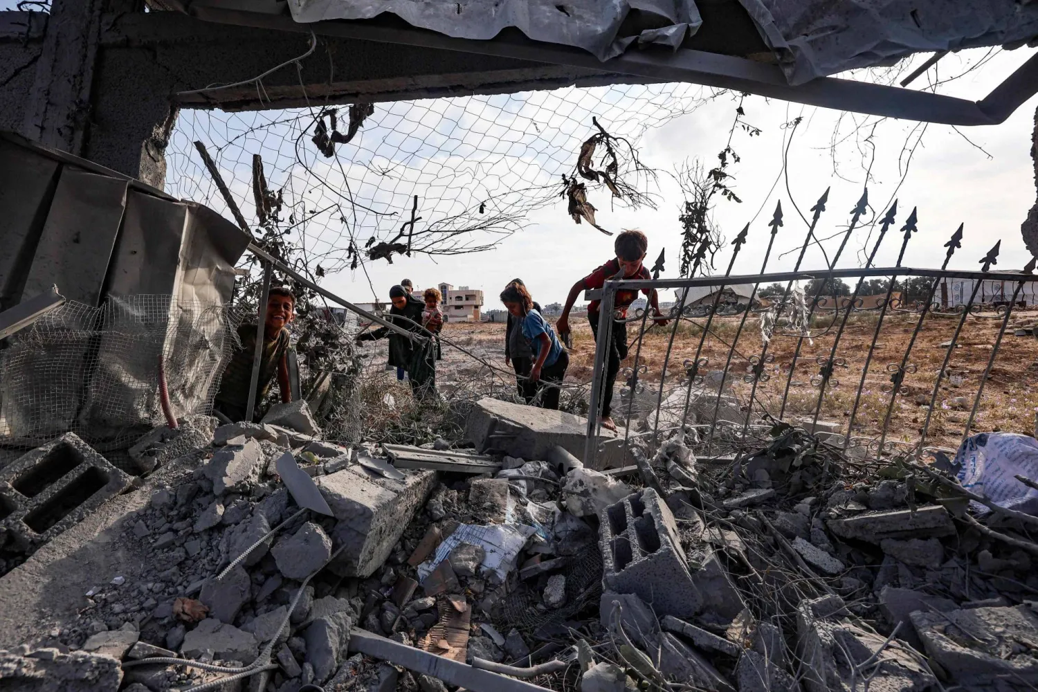 أطفال فلسطينيون يتفقدون أنقاض مبنى تضرر في غارة إسرائيلية على مخيم البريج للاجئين بوسط قطاع غزة (أ.ف.ب)