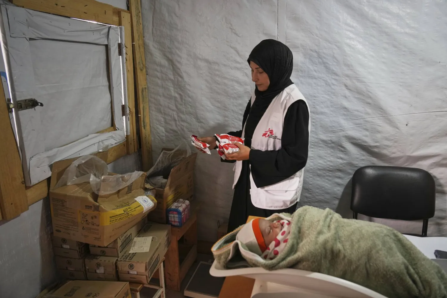 أطباء يزنون طفلاً فلسطينياً في عيادة «أطباء بلا حدود» في المواصي بالقرب من خان يونس في جنوب قطاع غزة (أ.ب)