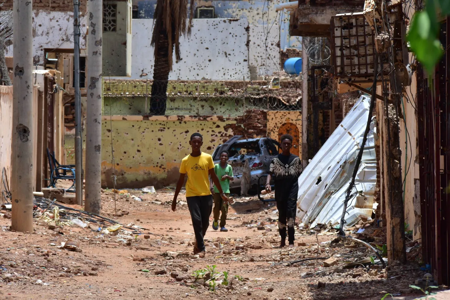أشخاص يسيرون في شارع يحمل آثار الدمار نتيجة صراع دموي على السلطة في السودان (أرشيفية - د.ب.أ)