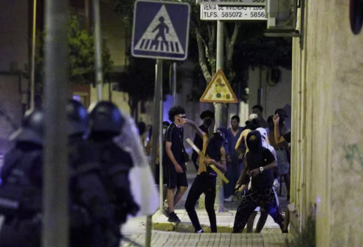 A man throws an object at police, amid anti-migrant unrest following an attack on an elderly man by unknown assailants earlier in the week, in Torre Pacheco, Spain, July 13, 2025. REUTERS/Violeta Santos Moura 