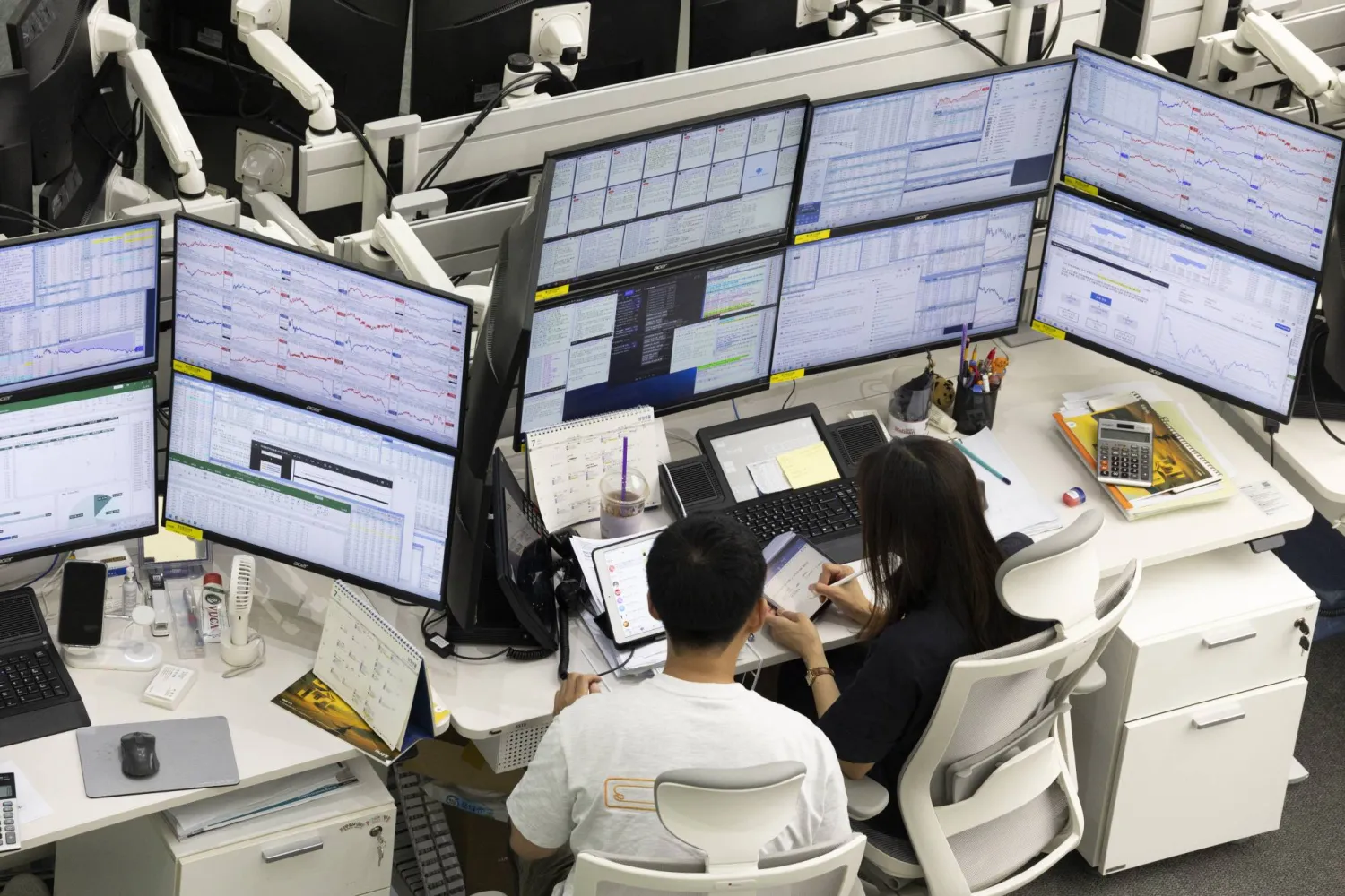 وسطاء لدى «بنك هانا» في أثناء التداول بسيول (إ.ب.أ)