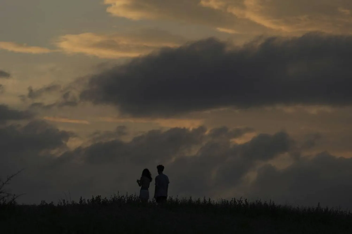  A couple watches a storm passes in the distance, Tuesday, July 15, 2025, in San Antonio. (AP) 