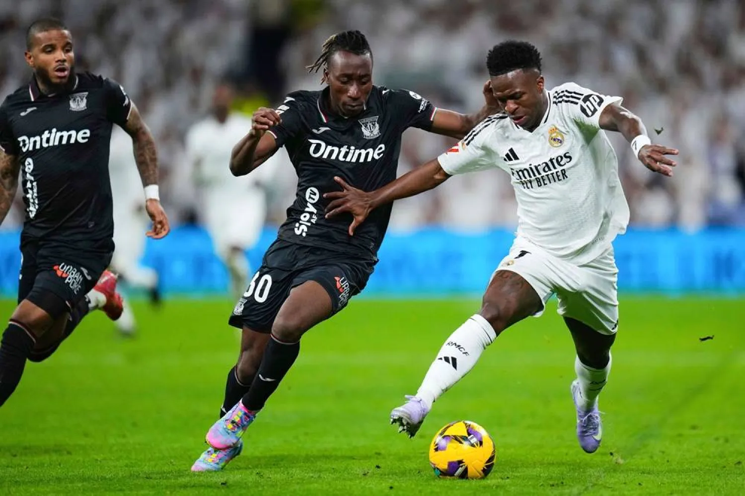 Leganes' Yan Diomande, center, and Real Madrid's Vinicius Junior fight for the ball during a Spanish La Liga soccer match between Real Madrid and Leganes at the Santiago Bernabeu stadium in Madrid, Spain, March 29, 2025. (AP)