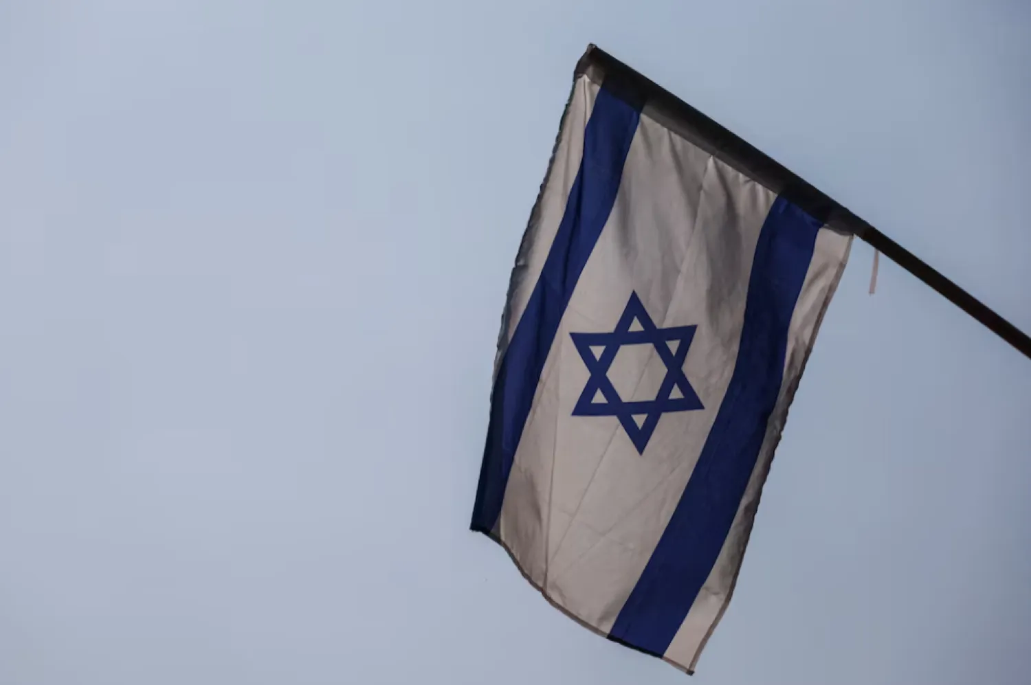 An Israeli flag is seen at the entrance to a school in Kibbutz Amir near Israel's border with Lebanon, in northern Israel, October 10, 2023. REUTERS/Lisi Niesner 