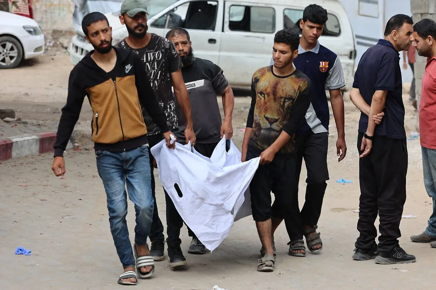 Zikim Sınır Kapısı yakınlarındaki bir dağıtım noktasından yardım almaya çalışırken öldürülen bir adamın cesedini taşıyan Filistinliler (AFP)
