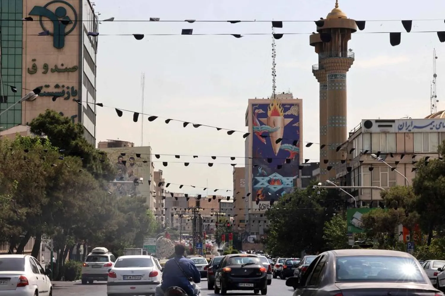 Traffic flows past a huge billboard bearing a painting of a missile falling on Israel with the slogan in Farsi: "The missile has fallen amidst the demons", on a main road in central Tehran on July 16, 2025. (AFP)